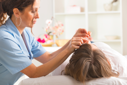 A practitioner performing an acupuncture treatment
